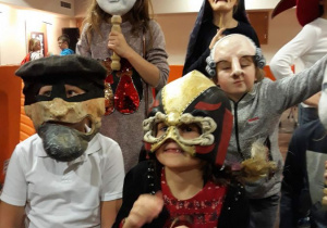 Uczniowie w maskach teatralnych.