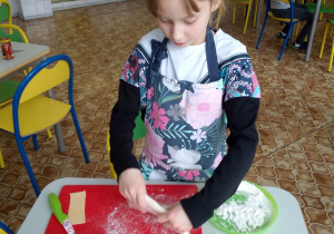 Michalinka szykuje ciasto na pizzę.