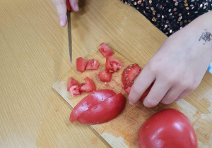 Uczennica klasy 1c kroi pomidora.