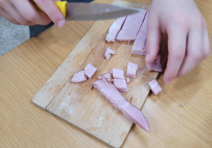 Uczeń klasy 1c kroi wędlinę.