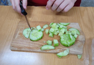 Uczeń klasy 1c kroi ogórka.